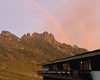 Rifugio alle primi luci del mattino con arcobaleno